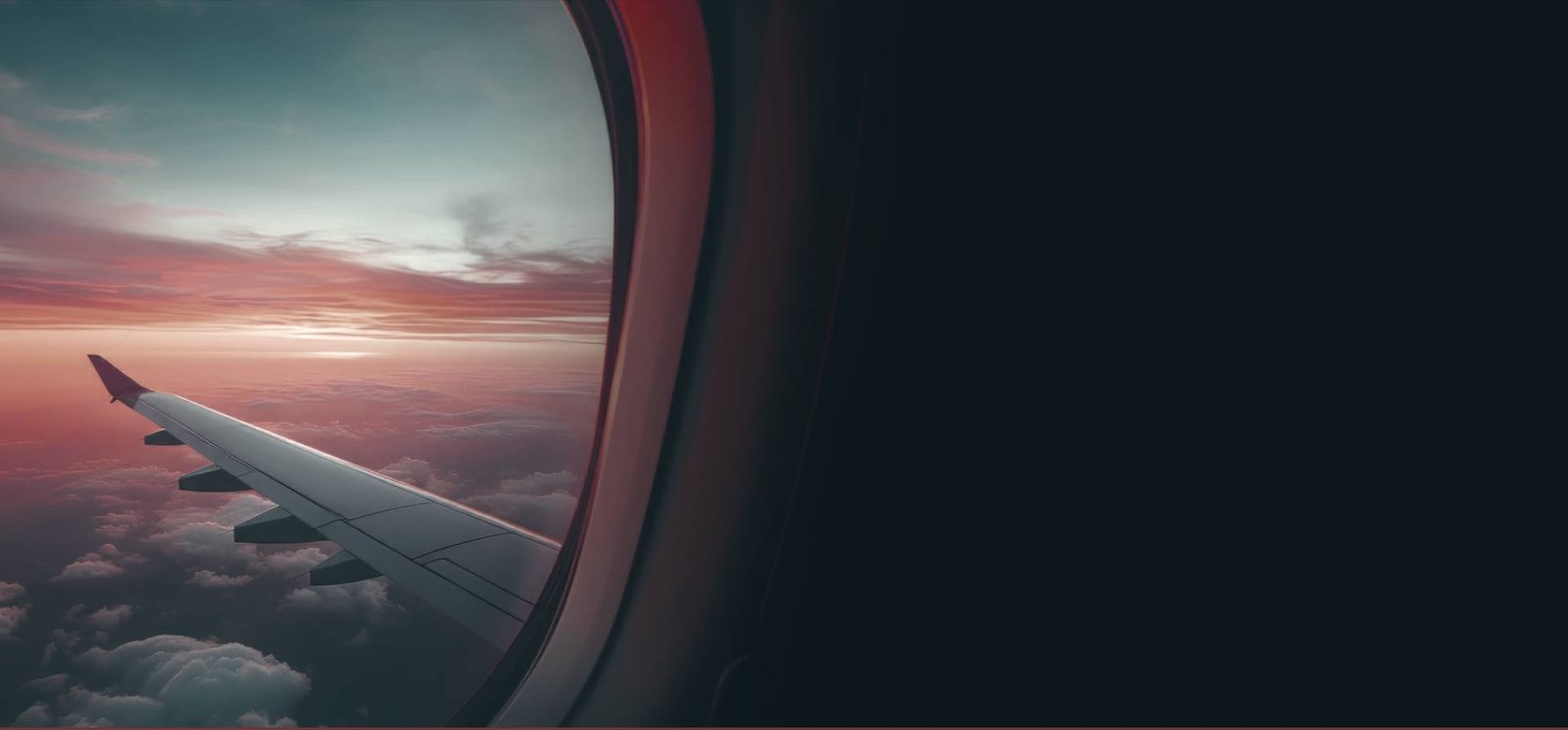 Vista da asa de um avião ao pôr do sol pela janela